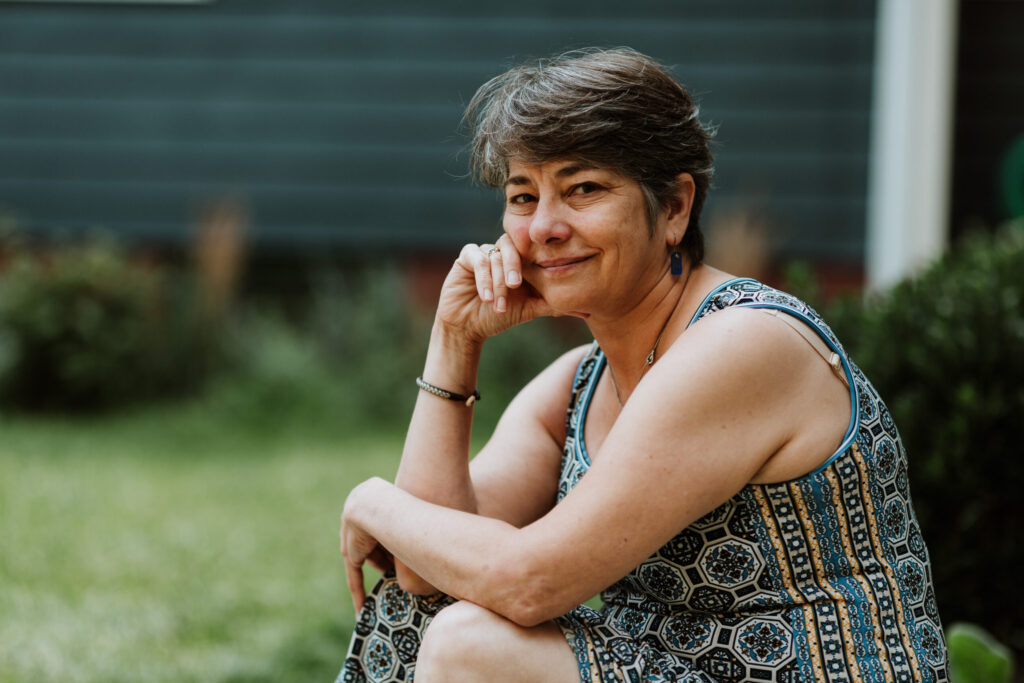 woman in a dress smiling hand on face