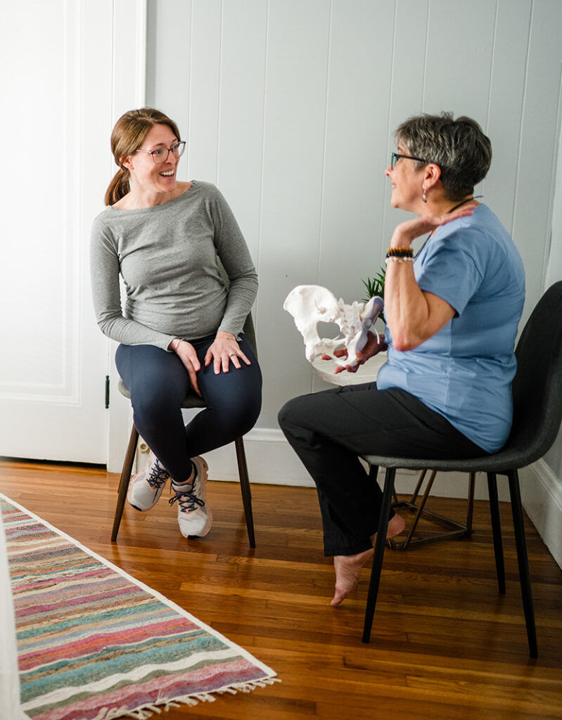 therapist speaking to a pregnant woman while sitting in chairs